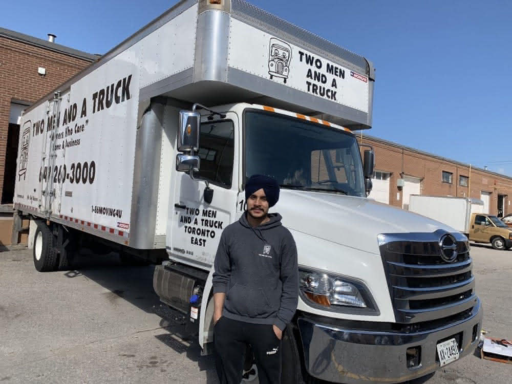 Iqbal Singh in-front of a company truck