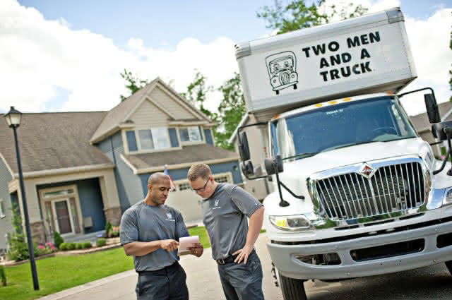 Two men and a truck movers reviewing a quote
