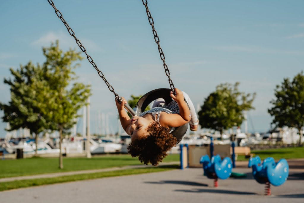 Oakville, Ontario Canada. 

Child swinging by a marina